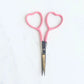 Pink-handled scissors on a white background