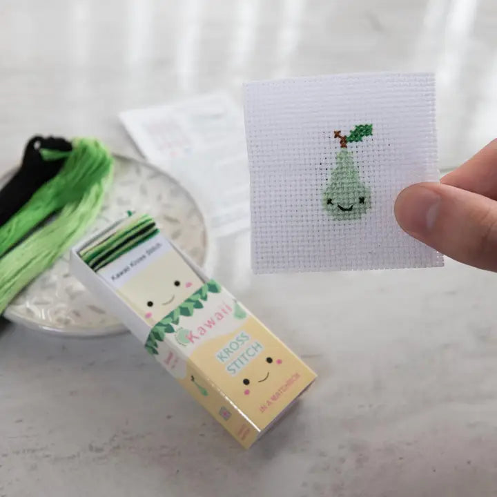 Cross-stitch kit with a small embroidered design on a white surface