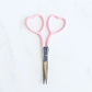 Pink-handled scissors on a white background