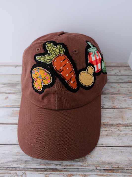 Brown cap with colorful vegetable patches on a wooden surface