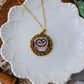 Necklace with an embroidered pendant on a decorative white plate