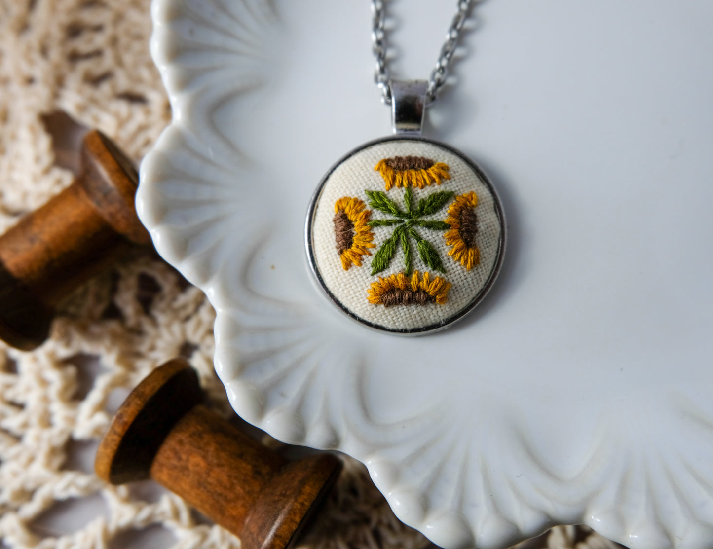 Necklace with embroidered pendant on a decorative plate