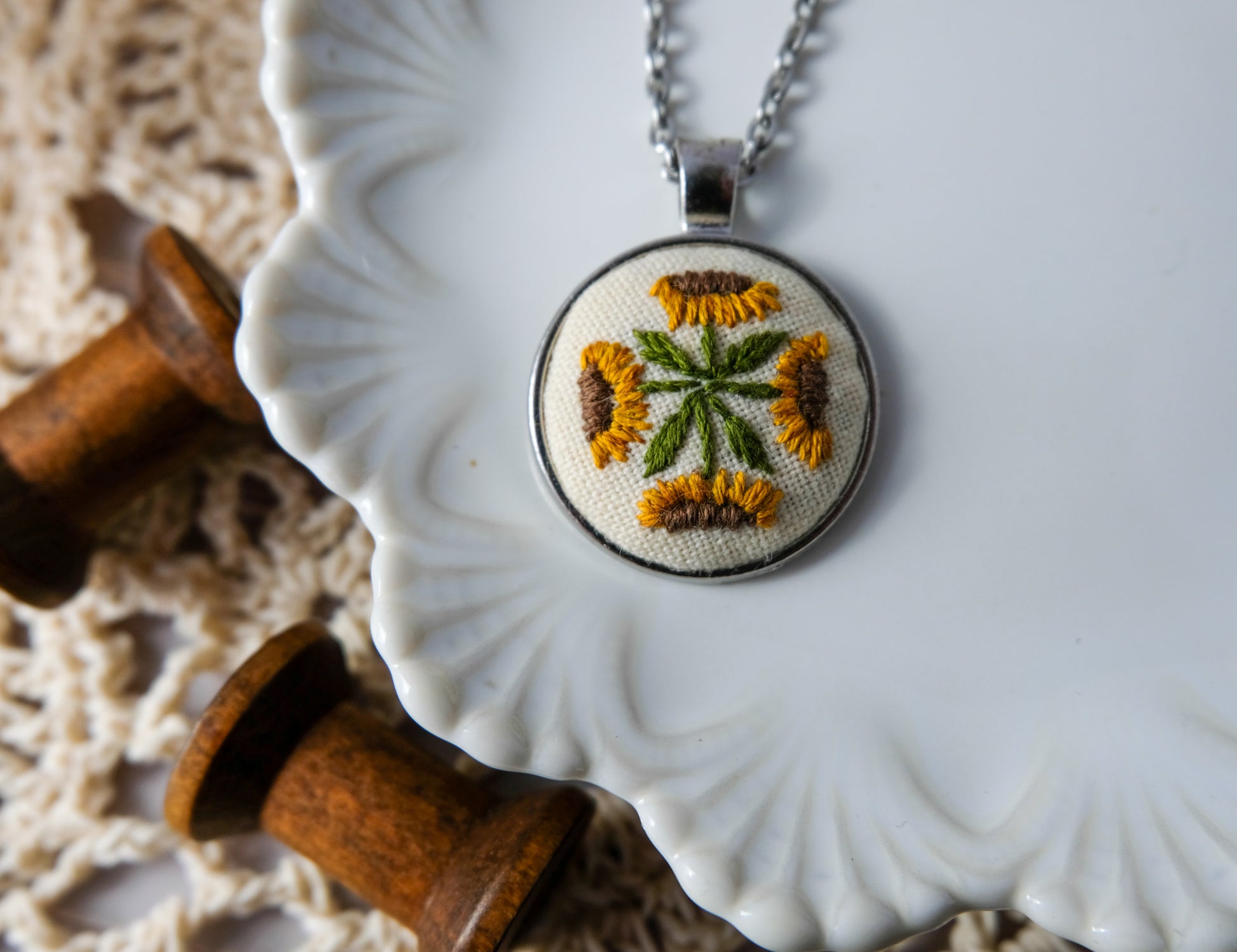 Necklace with embroidered pendant on a decorative plate