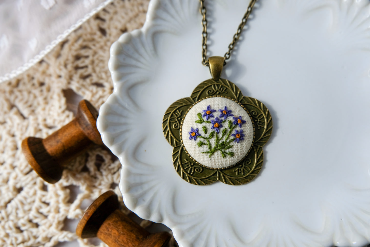Necklace with embroidered pendant on a decorative plate