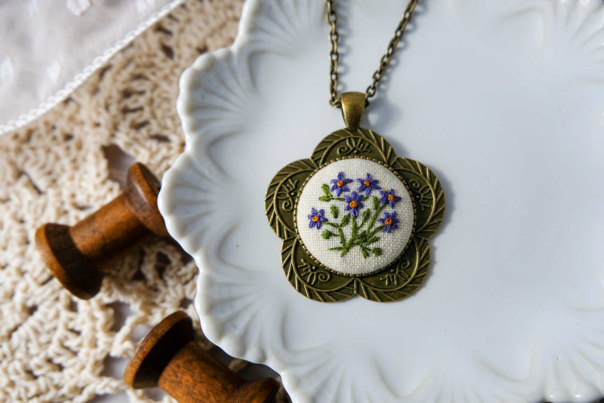 Necklace with embroidered pendant on a decorative plate