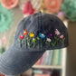 Blue cap with embroidered colorful flowers against a blurred background