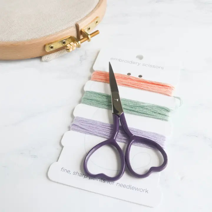 Embroidery scissors and thread on a white background
