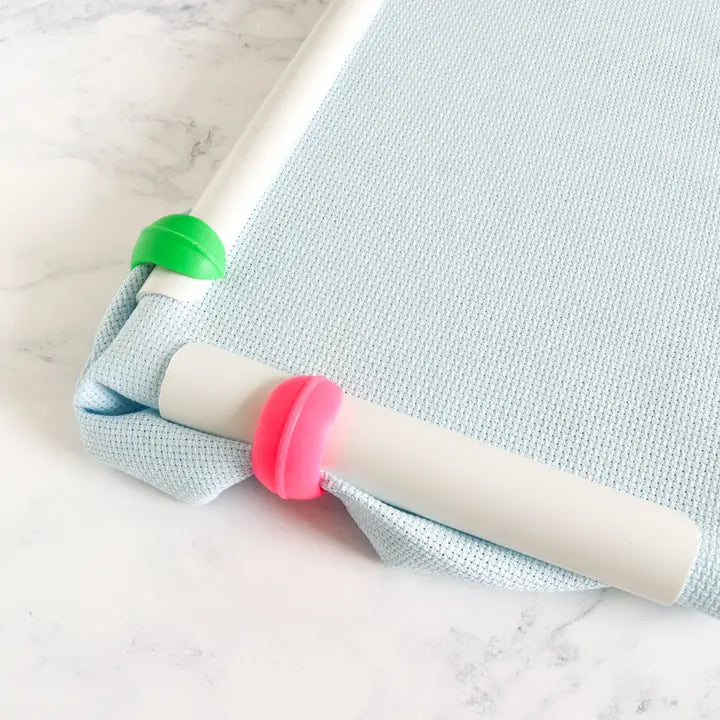 Silicone hoop huggers holding excess fabric away from the stitching area in multi colors