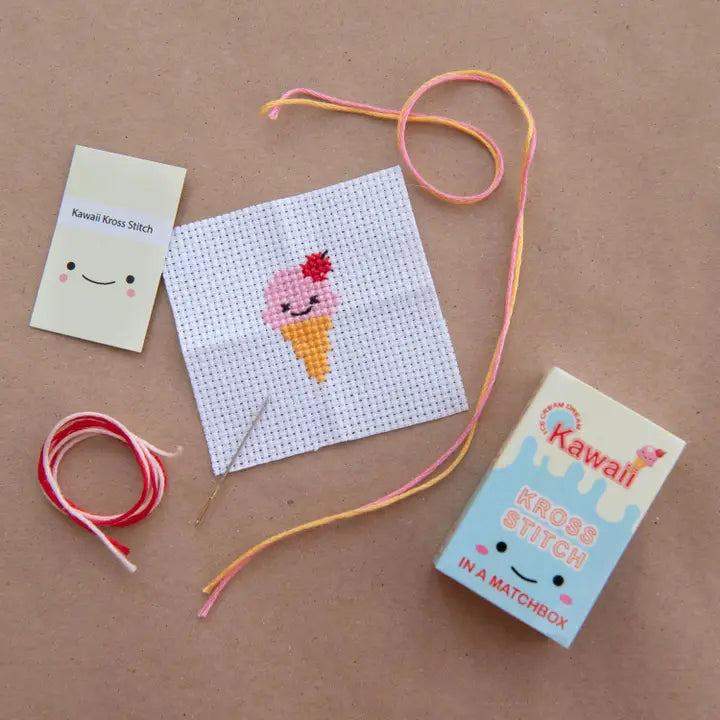 Cross-stitch kit with a pre-printed pattern of an ice cream cone on a brown background.